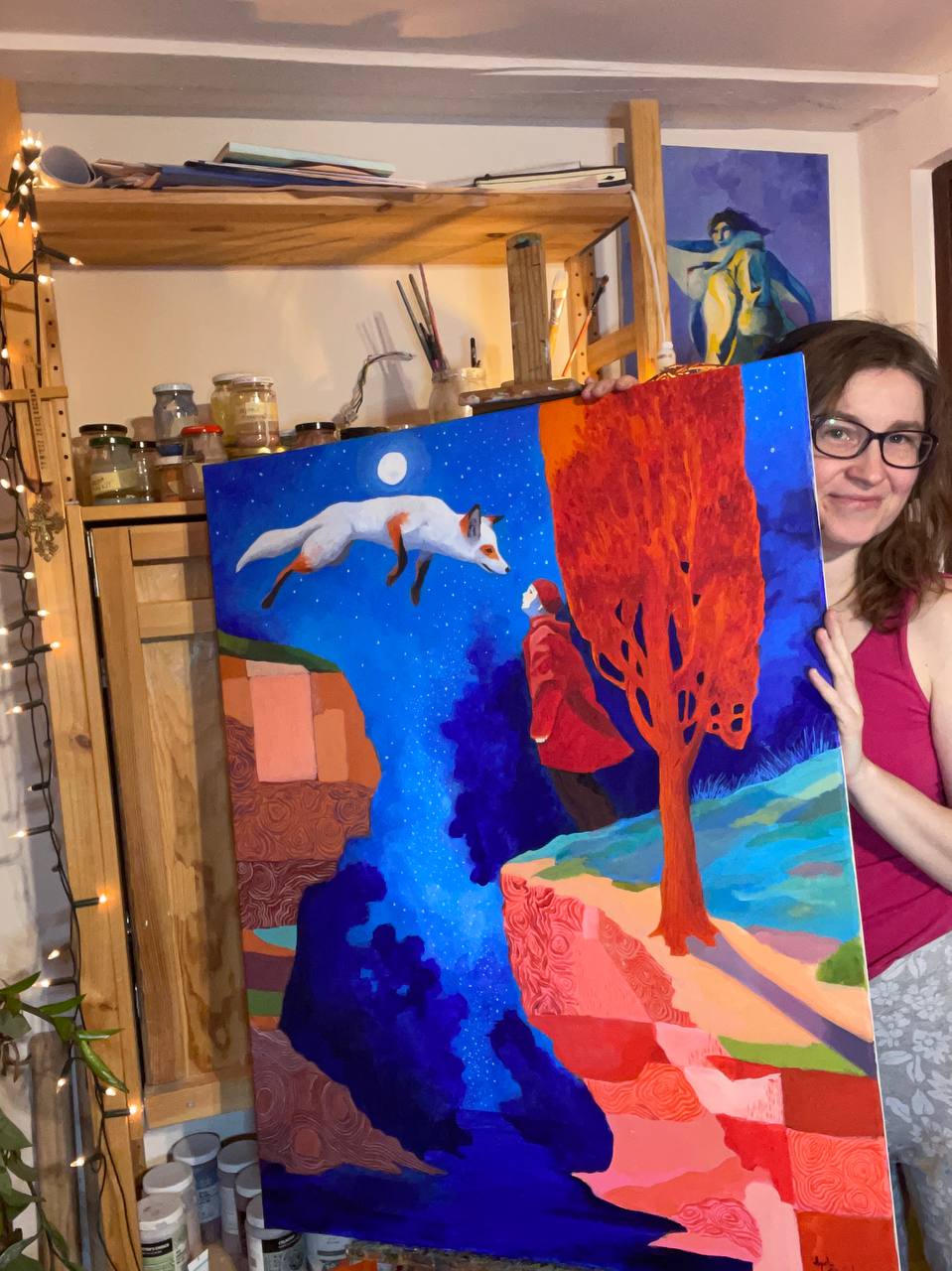 Agata Sliwinska holding the finished Above the Canyon painting in her studio